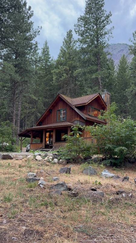 The cabin nestled in the pines with a covered porch