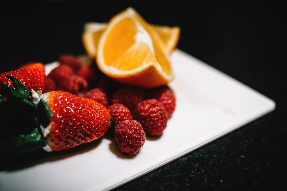 A plate of fresh strawberries and raspberries